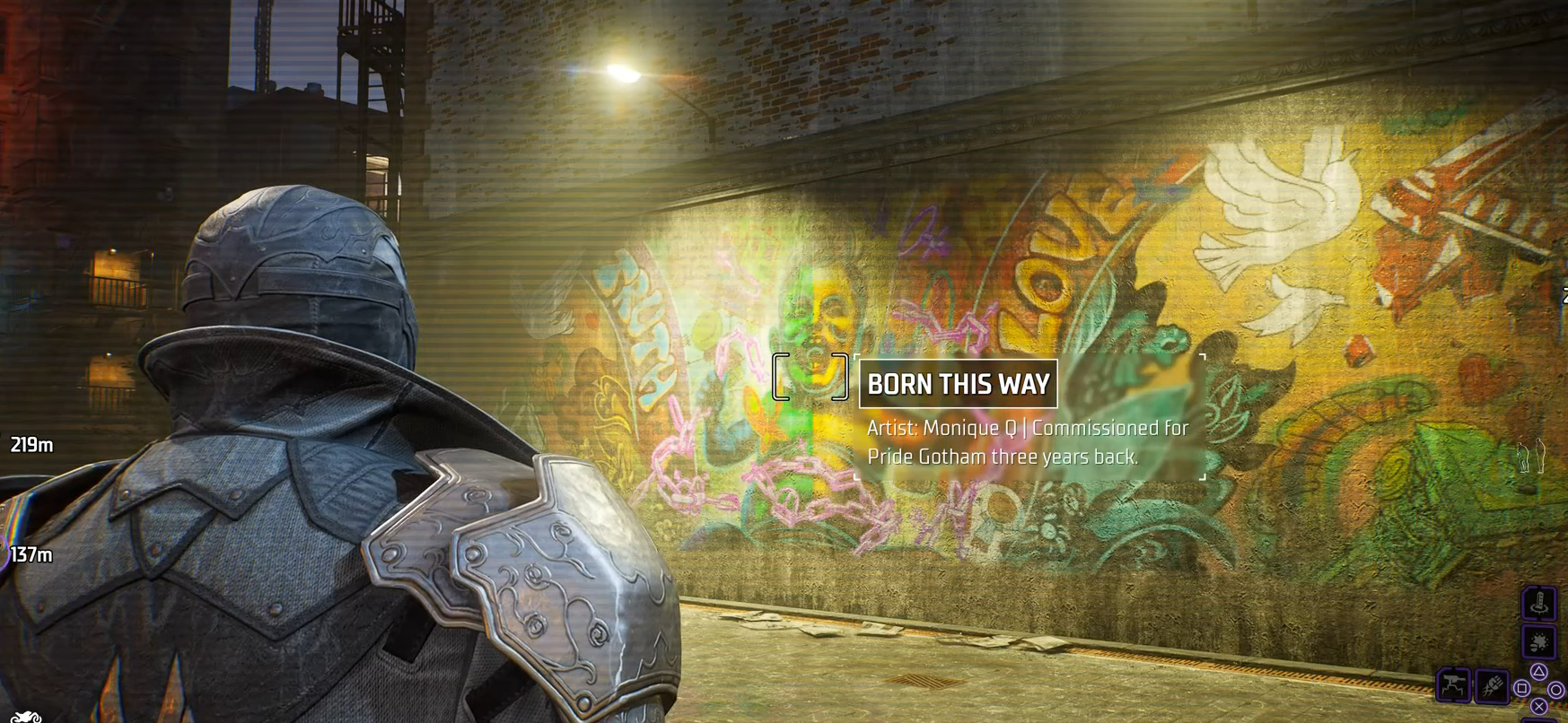 The player character of Gotham Knights stares at the colorful "Born This Way" mural. The mural prominently features a laughing baby framed by the words "truth" and "love".